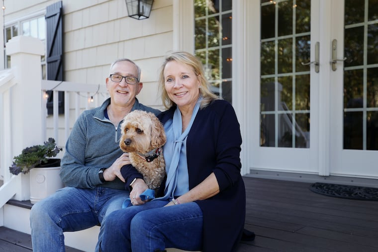 Susanne LaFrankie-Principato and Bob Principato with their Cavapoo, Marty, on the rear porch they added as part of expansions of the home.
