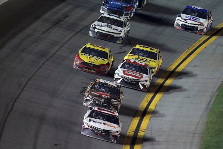 Denny Hamlin (11) takes the checkered flag to win the NASCAR Daytona 500 auto race Sunday, Feb. 17, 2019, at Daytona International Speedway in Daytona Beach, Fla.