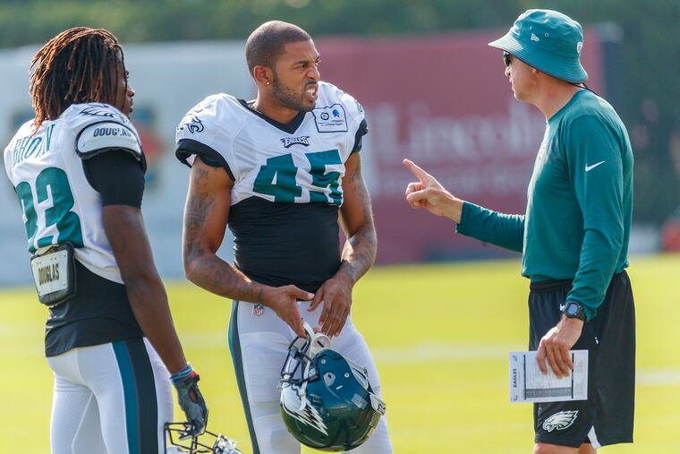 Former Cowboy turned Eagles cornerback Orlando Scandrick, center, listens to a coach, along with fellow newcomer Alex Brown, left, during training camp at the NovaCare Complex on Monday.