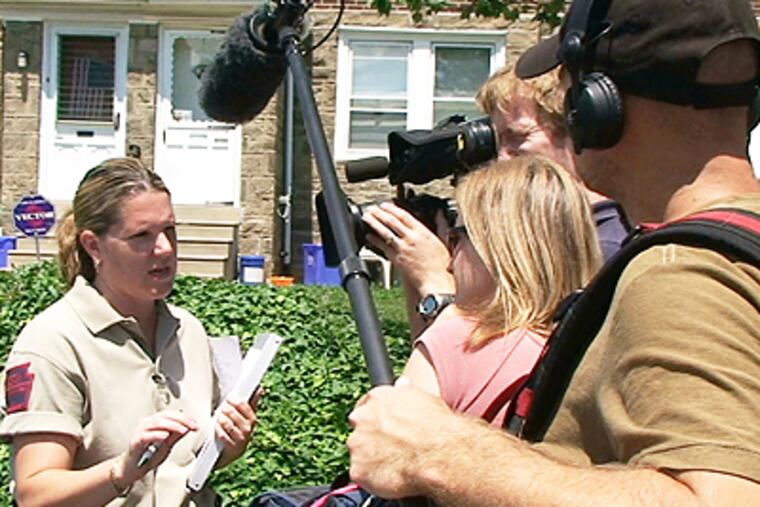 Darlene Sosa, a humane law officer for the Pennsylvania Society for the Prevention of Cruelty to Animals, is interviewed by a camera crew from the TV show "Animal Cops." (Bob Moran/Inquirer)