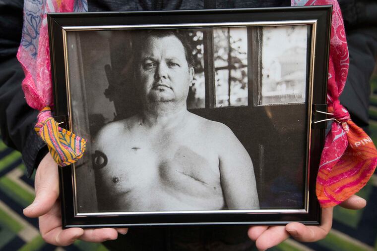 Men get breast cancer, too. Michael Singer of the Male Breast Cancer Coalition displays a photograph of the late Bill Becker, originally taken by photographer David Jay.