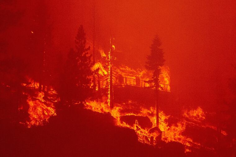 Flames consume a home as the Caldor fire pushes into South Lake Tahoe, Calif.