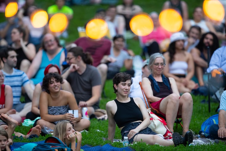 Spectators in Clark Park watch the performance with lights in the foreground. Shakespeare in Clark Park is back this weekend.