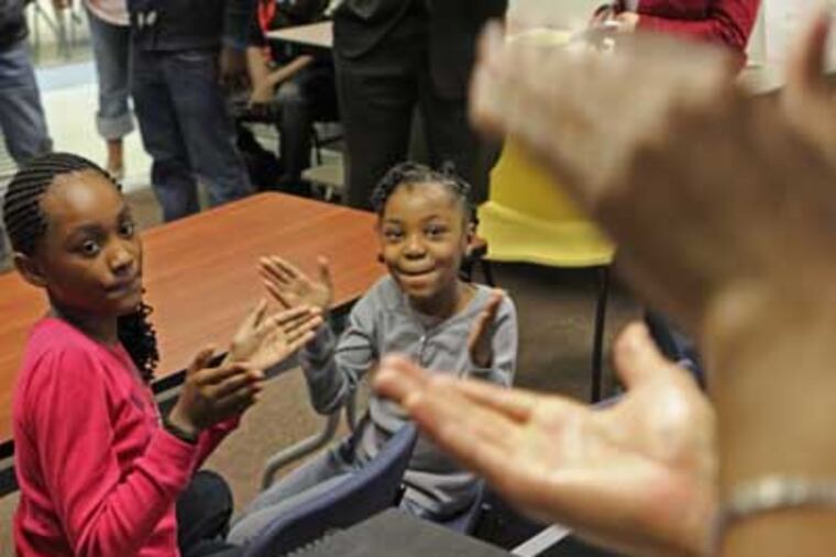 While Joseph Reynolds, a Philadelphian musician, right, claps out the beat to a piece of music, Destini McDaniels, 10, left, and Ijae Johnson, 8, center, clap along with him. ( MICHAEL BRYANT / Staff Photographer )