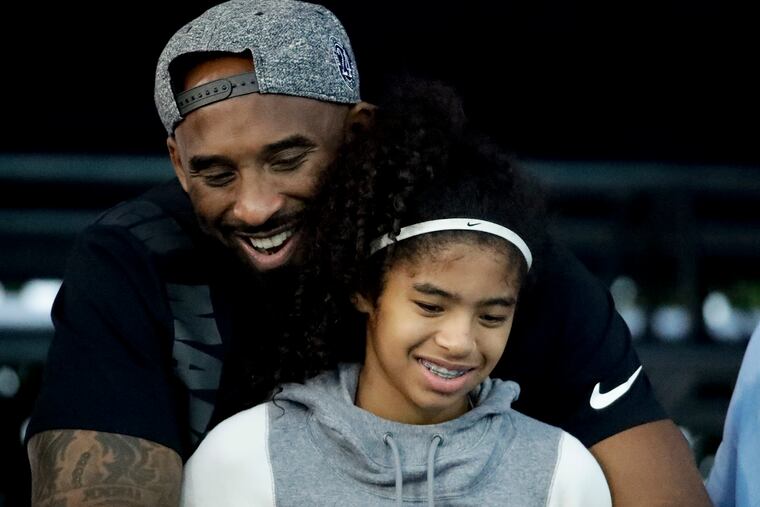 In this July 26, 2018, file photo former Los Angeles Laker Kobe Bryant and his daughter Gianna watch during the U.S. national championships swimming meet in Irvine, Calif.