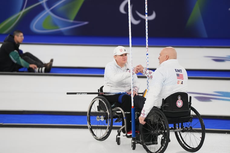 Steve Emt, right, and Laura Dwyer, of the United States, bump fists during their wheelchair curling mixed doubles round robin session against Japan on March 5 at the 2026 Winter Paralympics, in Cortina d'Ampezzo, Italy.