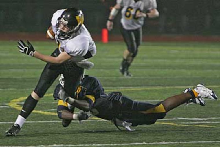 Archbishop Wood's Vince Furlong is tackled by West Catholic's Raymond Maples during a game at Northeast High School in September. Archbishop Wood's Steve Devlin served apprenticeships under St. Joseph's Prep boss Gil Brooks.(Kevin Cook / Inquirer)