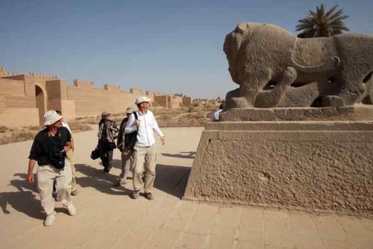 Members of a team from the World Monuments Fund and State Department gaze at a sculpted lion during their visit to the site.