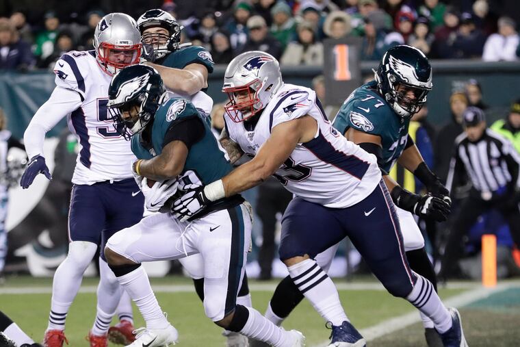 Eagles running back Miles Sanders gets stopped against New England Patriots defensive tackle Lawrence Guy during the third-quarter Sunday. Sanders had just 38 yards on 11 carries in the 17-10 loss.