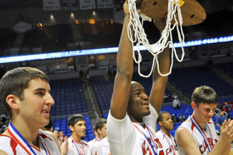 Archbishop Carroll's Andre Wilburn (21) shows the championship trophy to the fans at the end of the PIAA Class AAA boys' state championship basketball game. (AP Photo / Ralph Wilson)