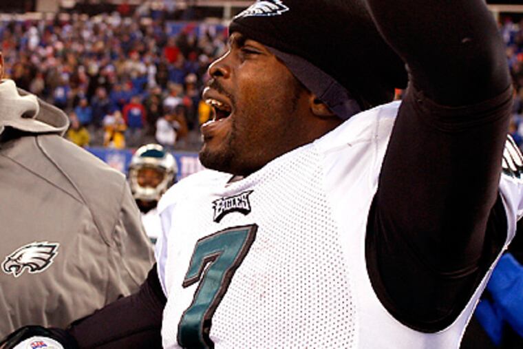 Michael Vick leads his teammates off the field after defeating the Giants, 38-31. (David Maialetti / Staff Photographer)