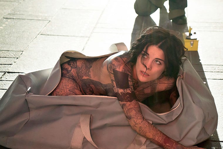 Jaimie Alexander emerges from a duffel bag in the pilot of "Blindspot," covered in tattoos that spark a mystery. VIRGINIA SHERWOOD / NBC