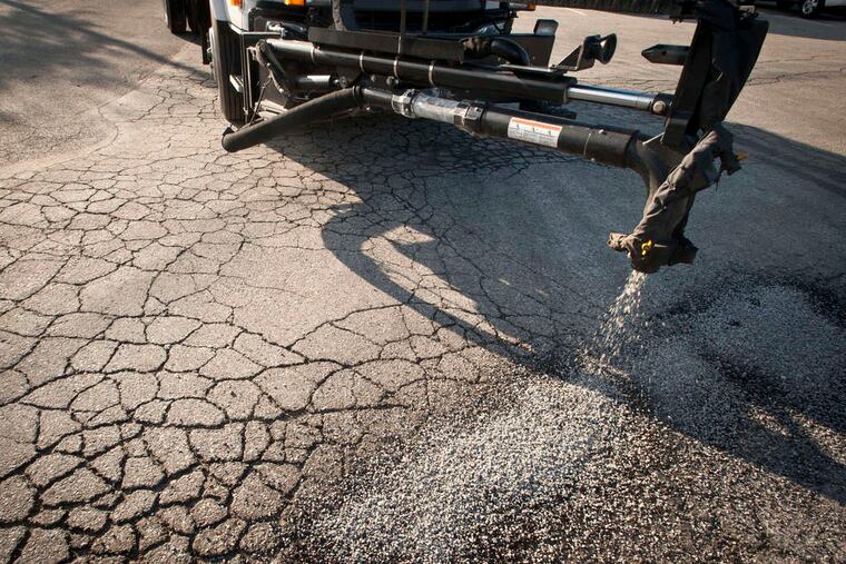 The boom on a Pothole Killer forces patching material into a pothole in the Juniata Park section of the city.