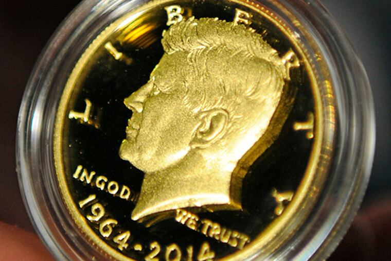 A U.S.Mint worker displays a 50th anniversary commemorative Kennedy half-dollar. (TOM GRALISH / Staff Photographer )