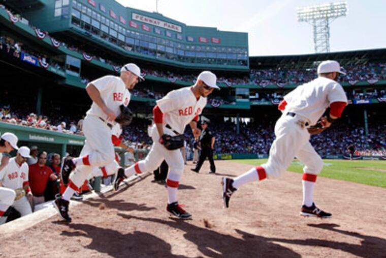 Red Sox players take the field in throwback uniforms to celebrate the 100th anniversary of Fenway Park's first game. (Elise Amendola/AP)