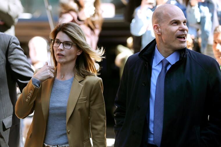 In this April 3, 2019, photo, Lori Loughlin, left, arrives at federal court in Boston with her attorney Sean Berkowitz to face charges in a nationwide college admissions bribery scandal.