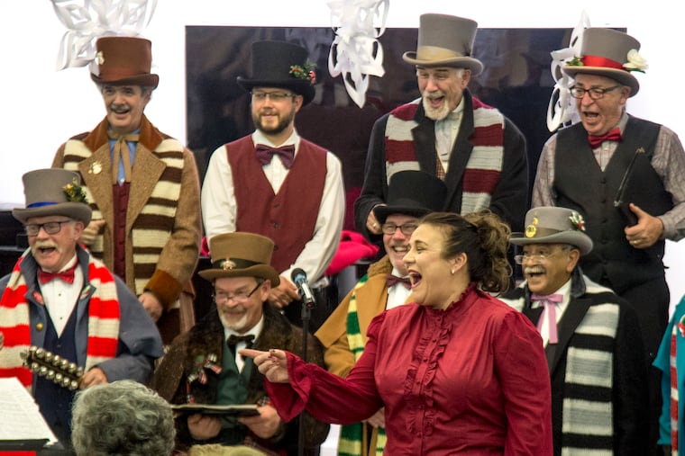 Lee Neamand (foreground), 44, Levittown, the conductor of the Men of Harmony choir, and the choir share a laugh with the residents of Attleboro Village in Langhorne where they gave a Christmas concert Tuesday.