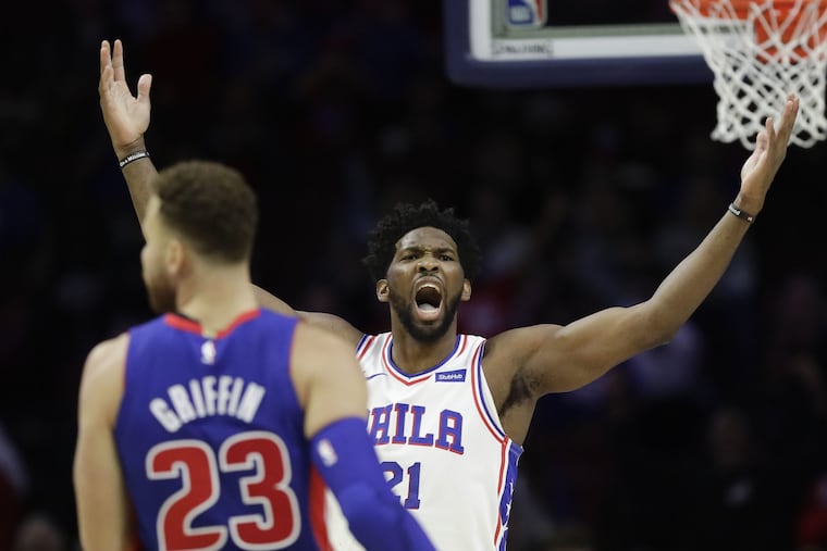 Sixers center Joel Embiid raises his arms near Detroit Pistons forward Blake Griffin on Saturday.