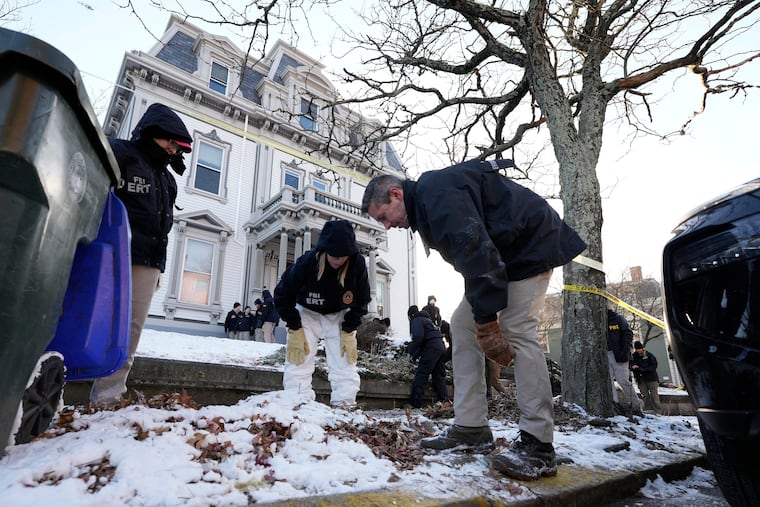 FBI Evidence Response Team members search for evidence near Brown University on Monday in Providence, R.I.