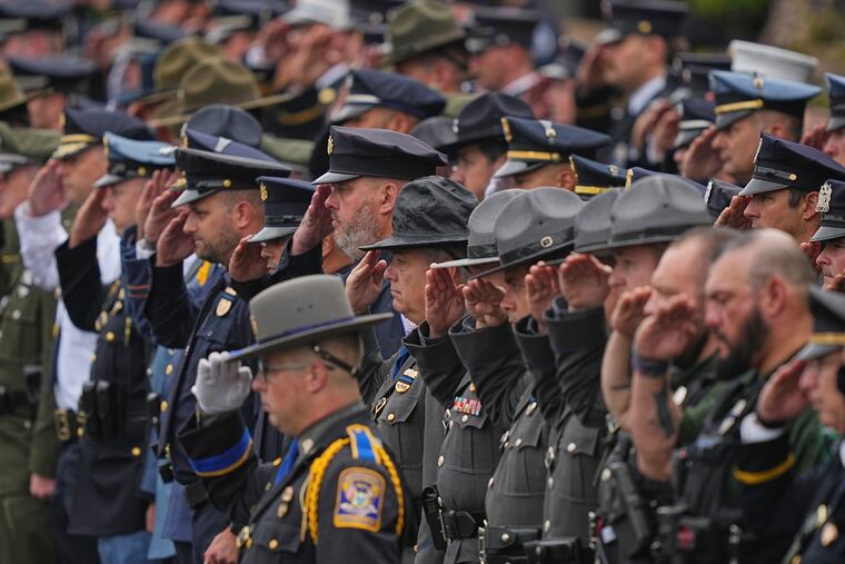 Officers salute during a procession for slain Northern York County Regional Police detectives Cody Michael Becker, Mark Edward Baker and Isaiah Emenheiser in Red Lion, Pa.