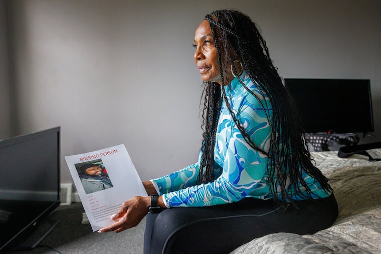 Claudia Fitzgerald holds a missing person flier for her son, Alexander, who was last seen June 21.