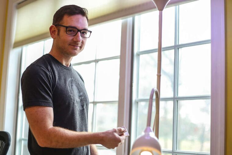 Gabriel Weinberg , founder of DuckDuckGo.com, holds a remote used to control the blinds at his company's headquarters in Paoli. ANDREW THAYER / Staff Photographer