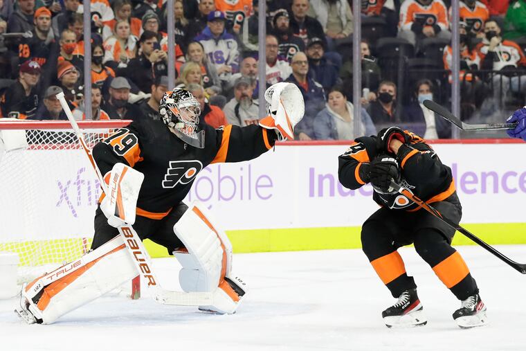Flyers defenseman Ivan Provorov ducks as goalie Carter Hart keeps his eye on a puck deflected by Lightning center Anthony Cirelli during the second period.