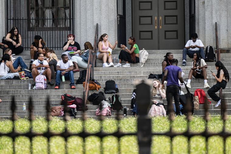 Students beat the heat by eating lunch outside on Thursday on the front Steps of South Philadelphia High School.