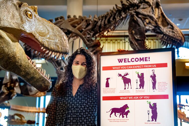 Designer Stephanie Gleit poses at the Academy of Natural Sciences of Drexel University Jan. 12, 2021 with the COVID signage she designed. She is one of the designers who create interesting COVID social distancing signage for their public spaces.
