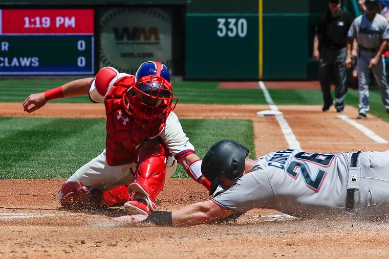 Andrew Knapp gets the tag down on the Marlins' Garrett Cooper on Sunday.