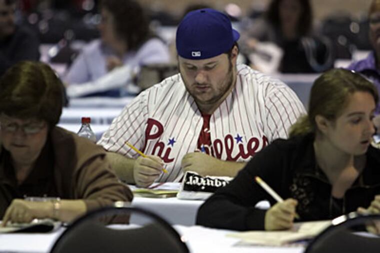 Joe Cosella, from Northeast Philadelphia, sports his Phillies garb while warming up for the Sudoku competition at the Pennsylvania Convention Center in Philadelphia today. (Laurence Kesterson / Inquirer)