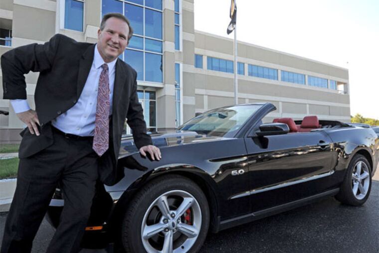 Kevin Cramton, CEO of Cardone Industries, the city's largest manufacturer, with his "baby." (April Saul / Staff Photographer)
