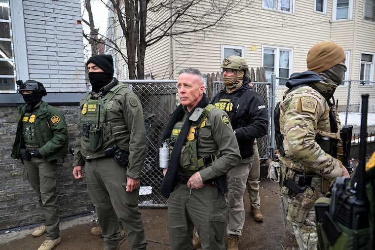 U.S. Border Patrol commander Gregory Bovino (center) and his agents watch as people taunt them during an arrest in Minneapolis on Jan. 8.