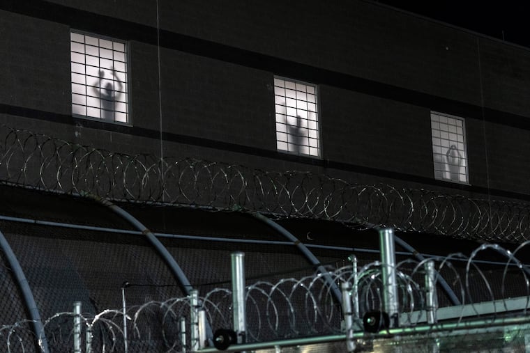 Inmate stand at windows at the Delaney Hall immigration detention center in Newark, N.J., as demonstrators gather outside on May 28.