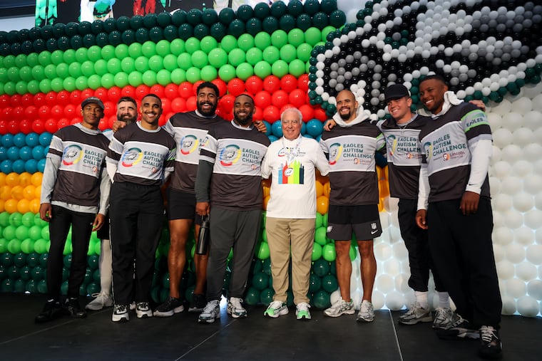 Eagles players and alum pose for a photo with owner Jeffrey Laurie during the Eagles Autism Challenge event at Lincoln Financial Field on Saturday.