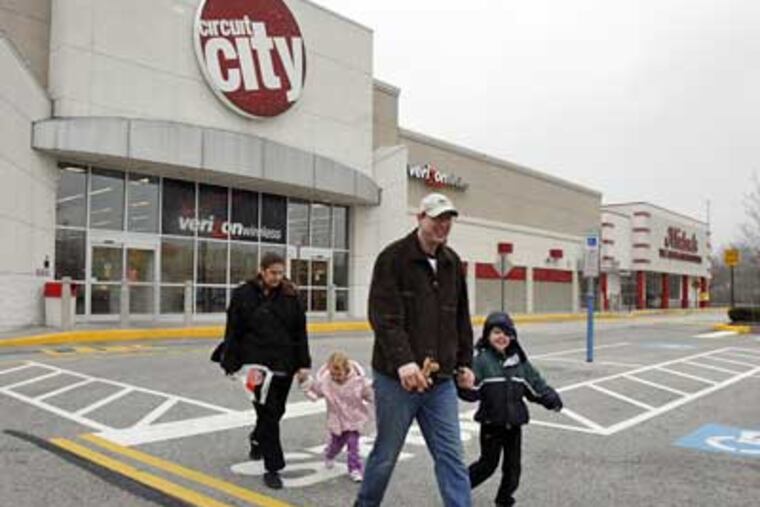 David and Anita Brennan, with children Jeremy (front) and Alexandra, walk to their car from Circuit City on Wednesday. (Bonnie Weller / Staff Photographer)