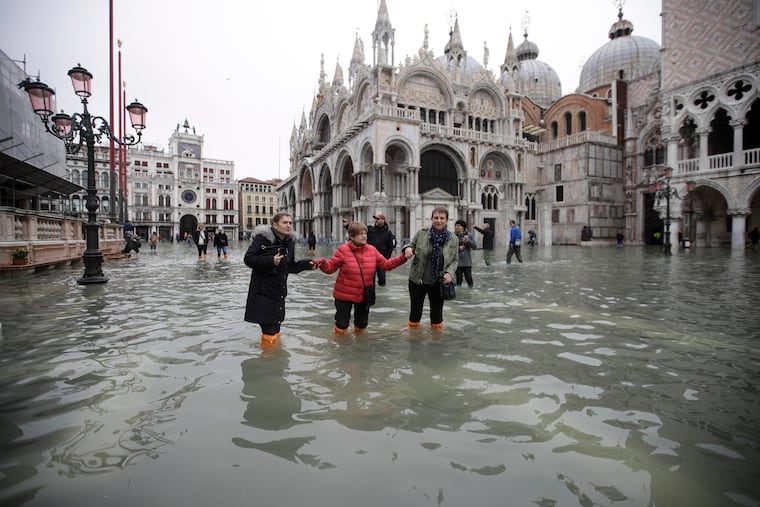 People wade through water in a flooded St. Mark's Square in Venice, Italy, on Wednesday.