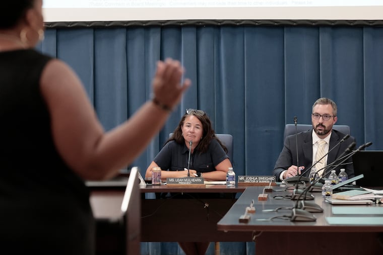 Taryn Knox (left) speaks to Leah Mulhearn, president of the Cheltenham school board, and Joshua Sweigard, director of business services, during Tuesday's board meeting. The school board was meeting for the first time since criminal charges against four football coaches and six players were announced, and since Brian Scriven resigned as superintendent.