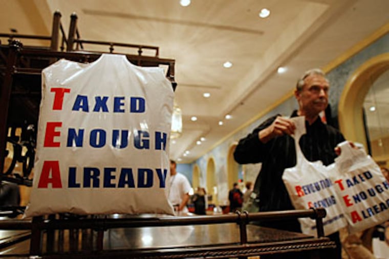 Bill Bruss of Winfield, Ill., gives away plastic bags in the vendor area at the National Tea Party convention in Nashville, Friday, Feb. 5, 2010. (AP Photo/Ed Reinke)