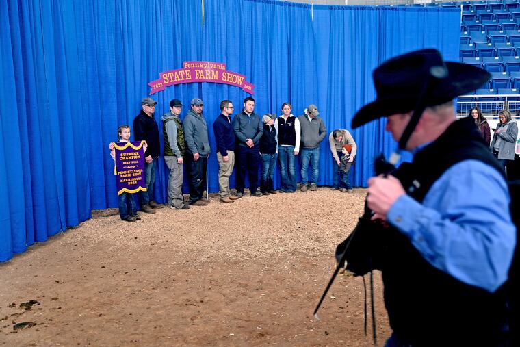 Kyle Grim leads his bull to the “Winners Circle” photo op backdrop. He won Supreme Champion Bull and Grand Champion Angus at the show,.