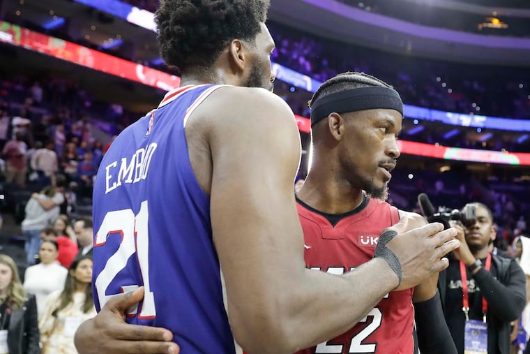 The Philadelphia 76ers' Joel Embiid (21) meets with the Miami Heat's Jimmy Butler.