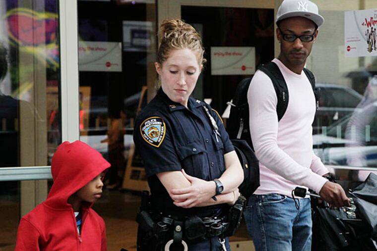 File photo: A New York City police officer watches as movie patrons arrive for a screening of "The Dark Knight Rises," Friday, July 20, 2012 in New York. (AP Photo/Mark Lennihan)