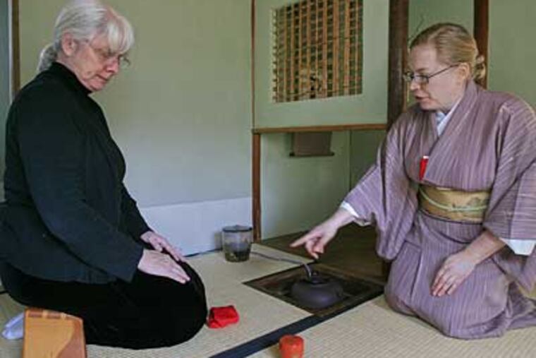 Teacher Morgan Beard (right) instructs Terry Sturmer in the nuances of the tea ceremony. In Japanese culture, tea ceremony is an art in which both students and teachers must be licensed, says Beard, a book editor in West Chester. (AKIRA SUWA / Staff Photographer)