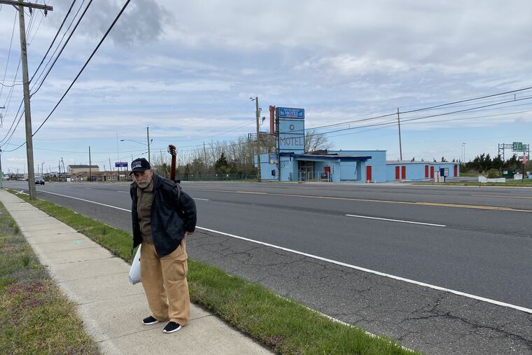 Guitar on his back, Michael McLain, 63, a former cab driver from Albany, N.Y., goes to catch a bus across from the New Sea Breeze Motel in West Atlantic City. He had been staying at the nearby Hi-Ho Motel but said the owner was charging too much. The West Atlantic City motels, part of Egg Harbor Township, are being eyed for housing COVID-19 positive homeless people from Atlantic City, according to Atlantic City officials.