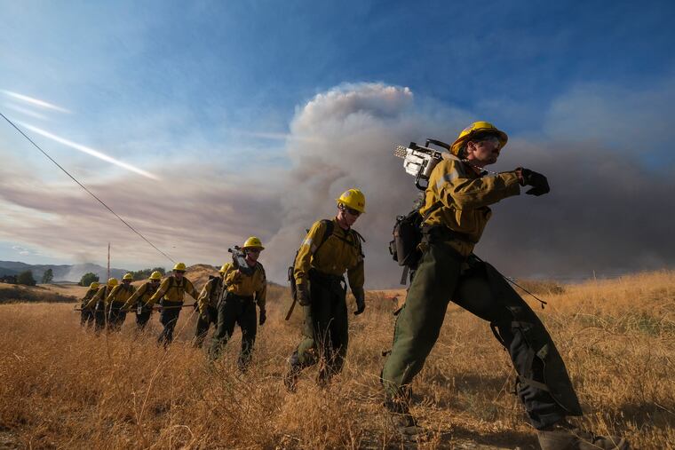 Firefighters walk in a line during a wildfire in Castaic, Calif., on Wednesday.