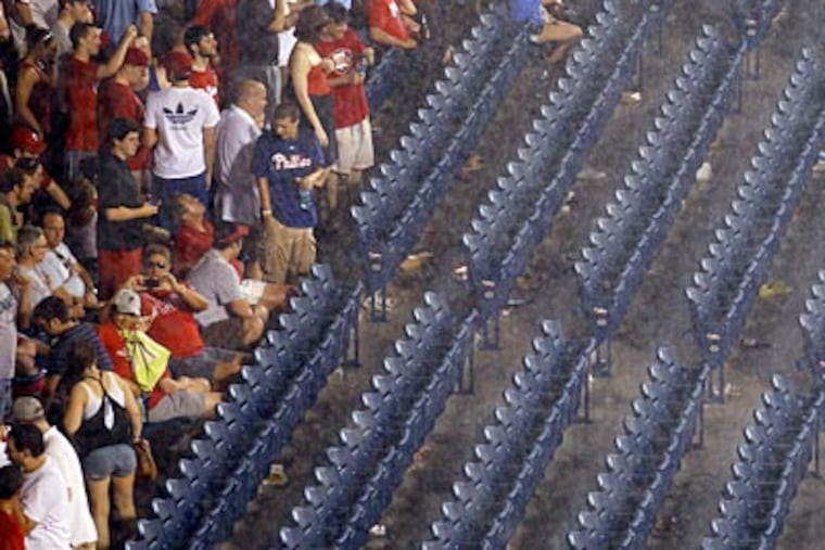 Phillies fans wait out the rain delay at Citizens Bank Park on Thursday night. (Yong Kim/Staff Photographer)