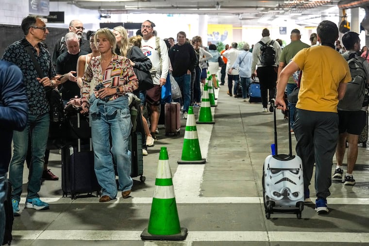 Airline passengers wait outside the terminal in the parking garage in long lines to get through the TSA security screening at William P. Hobby Airport in Houston, on March 8, 2026.