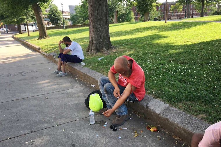 An unidentified man shoots up at the edge of McPherson Square Branch Library, 651 East Indiana.