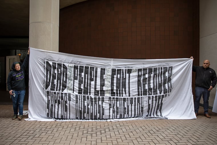 Shey Hall, left, 35, of New Jersey, and Evan Figueroa-Vargas, 37, of Mayfair, hold a banner in protest outside of the U.S. Attorney's office in Center City Philadelphia on Wednesday, Feb. 06, 2019. U.S. Attorney for the Eastern District of Pennsylvania William McSwain spoke during a press conference that morning, announcing civil enforcement action to stop supervised safe injection sites in Philadelphia.