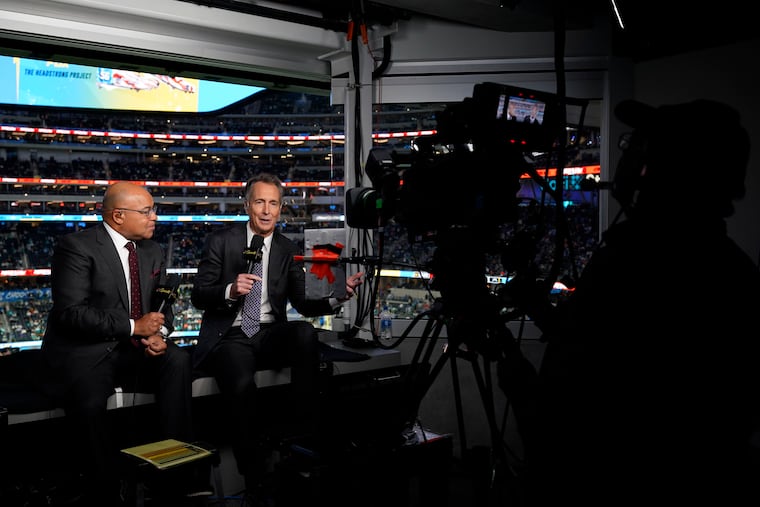 NBC Sports play-by-play announcer Mike Tirico, left, sits next to color commentator Cris Collinsworth before a “Sunday Night Football” game between the Los Angeles Chargers and the Miami Dolphins on Dec. 11, 2022.